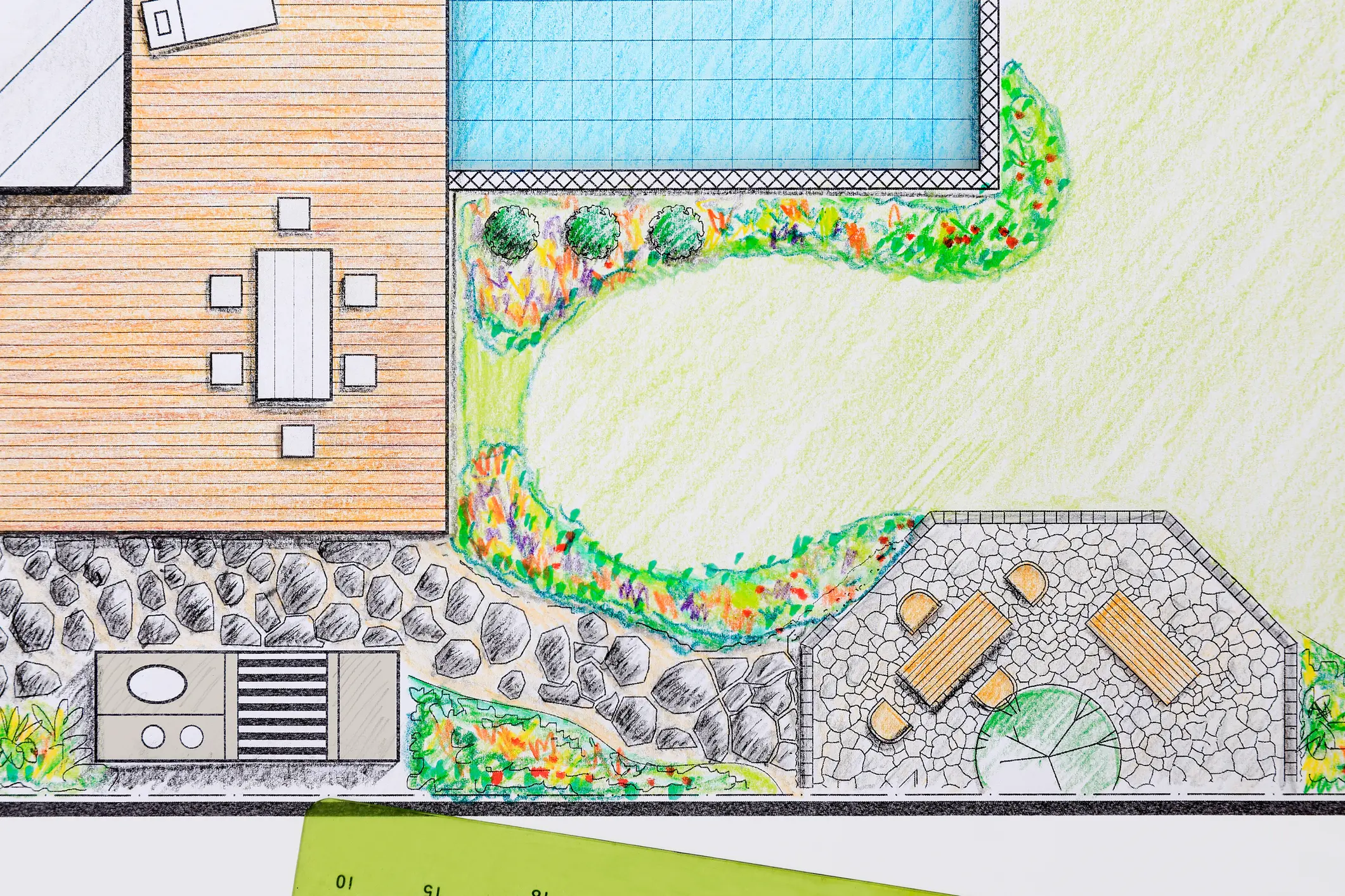 Colored landscape design plan overhead showing a backyard layout with a wooden deck and dining table, adjacent blue rectangular pool, curved lawn bordered by colorful planting beds and shrubs, stone paver pathway leading to an octagonal paved seating area with benches, and a small grilling/utility area — illustration for professional landscaping services, landscape design and installation.